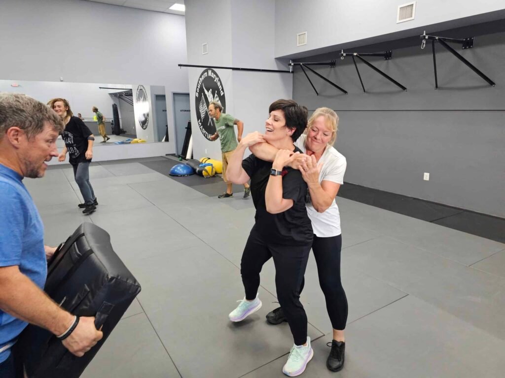 Women learning choke defense during Krav Maga training at Guardian Krav Maga LLC